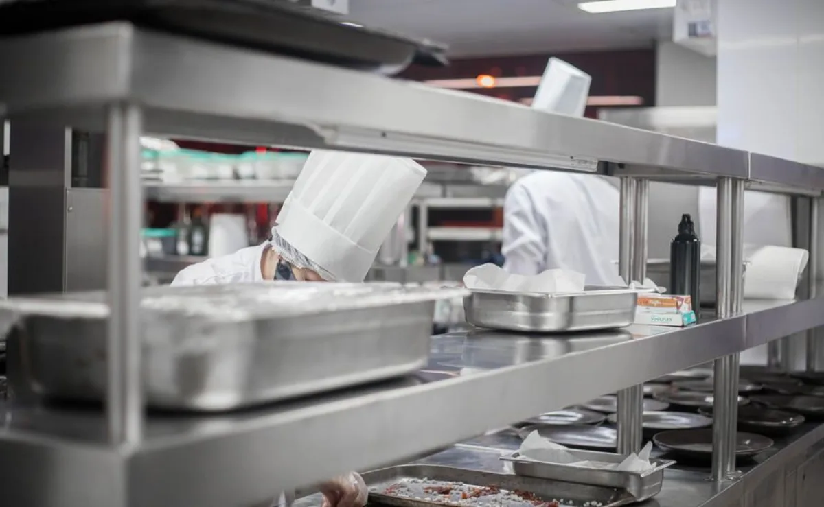 Chefs working in a clean professional stainless steel commercial kitchen