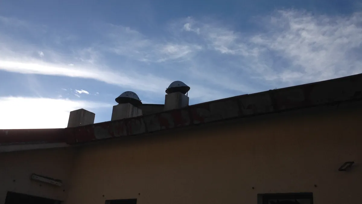 Several restaurant exhaust fans on a flat roof, the setting for exhaust fan repair work