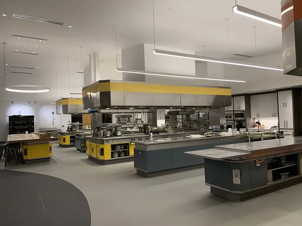 Commercial kitchen cooking islands under long stainless exhaust hoods, the hoods that hold the baffle filters