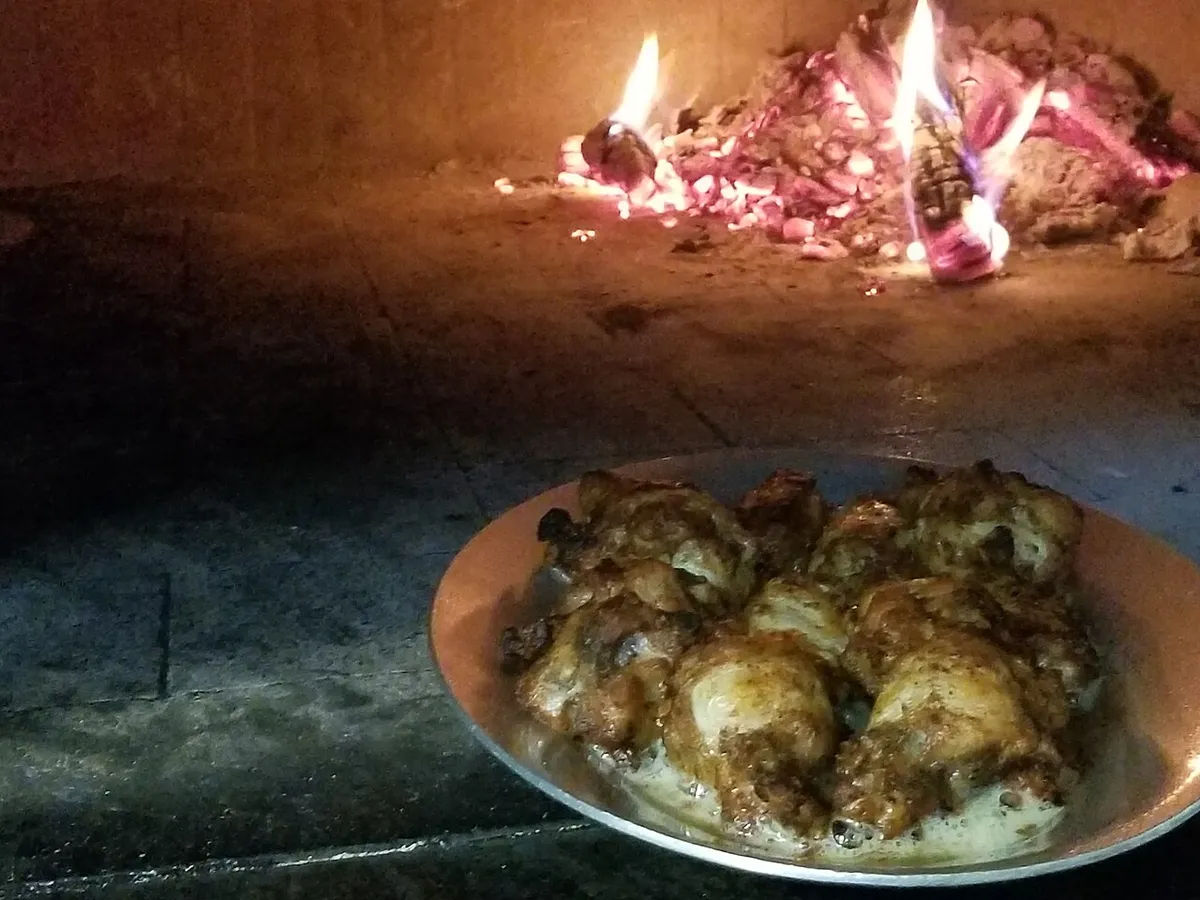 A live wood fire inside a restaurant oven, the source of the creosote a wood-fired oven hood cleaning removes